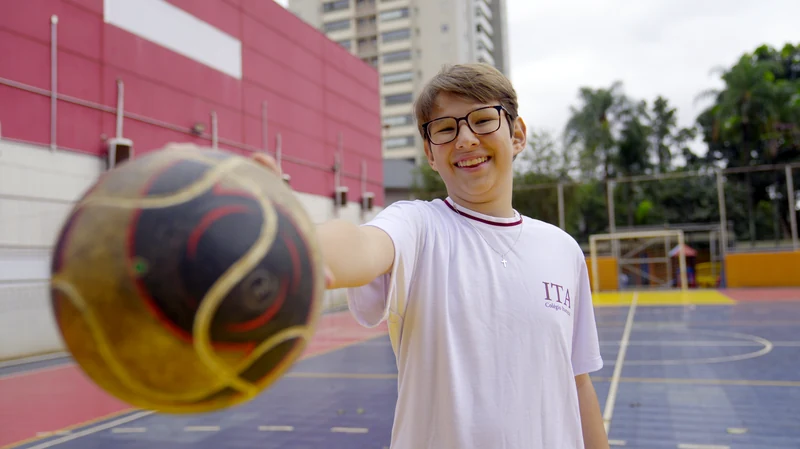 Aluno do Colégio Itamarati com uma bola de basquete