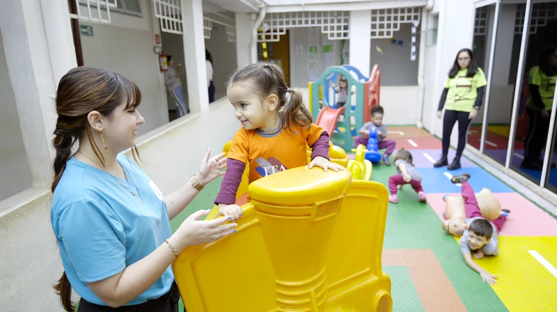 Professora do Colégio Itamarati brincando com uma criança no pátio
